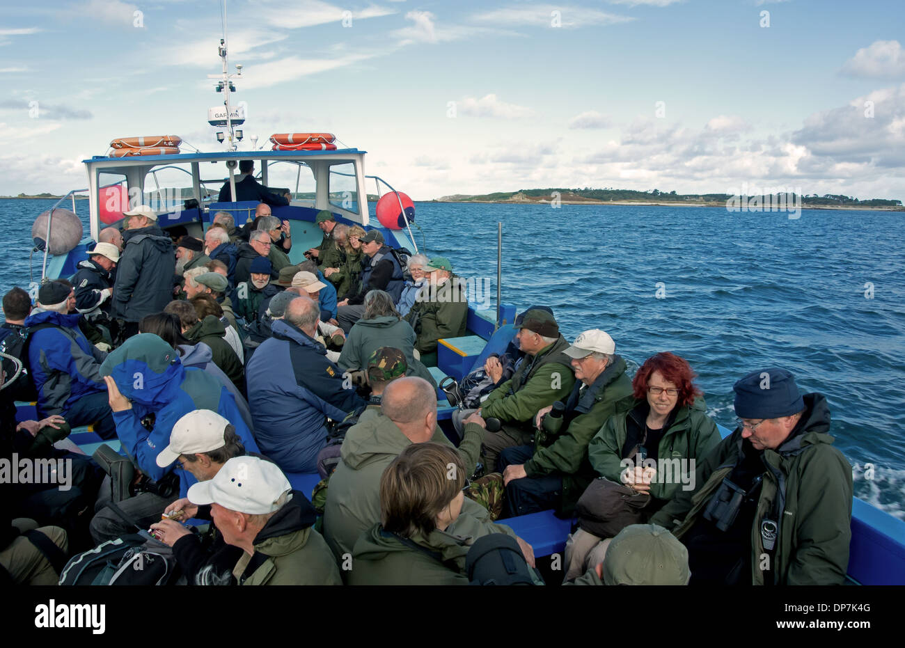 Gli amanti del birdwatching in barca, con Tresco in distanza, isole Scilly, Inghilterra, Ottobre Foto Stock