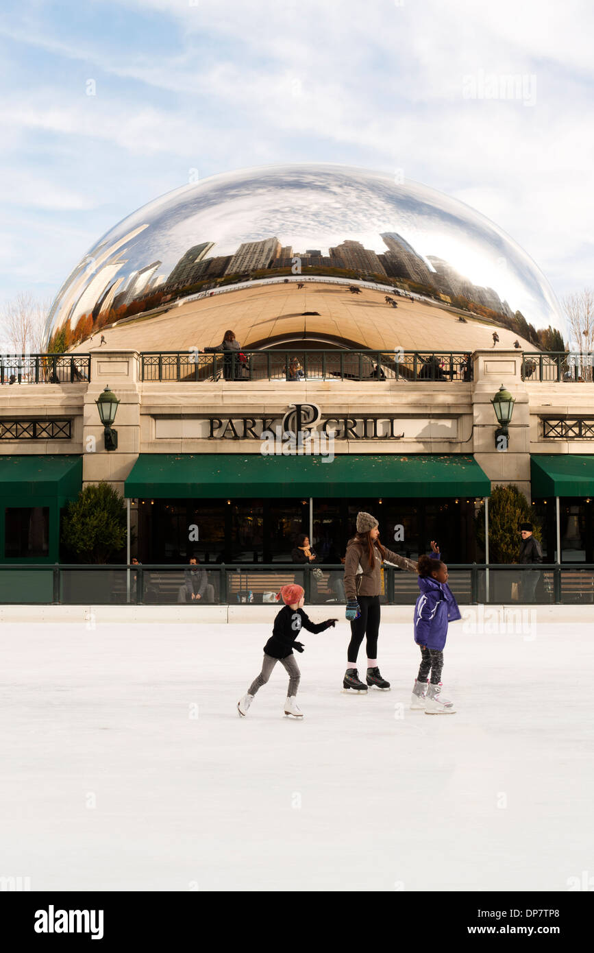 Persone pattino da ghiaccio a McCormick omaggio Plaza e la pista di pattinaggio su ghiaccio con il Cloud Gate sculpture dietro. Foto Stock