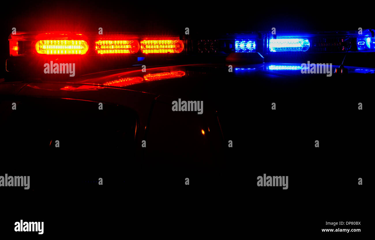 La parte superiore di una macchina della polizia con le sue luci accese di notte. Foto Stock