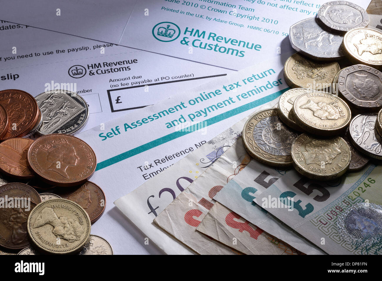HMRC Self Assessment di documenti cartacei con monete e denaro Foto Stock