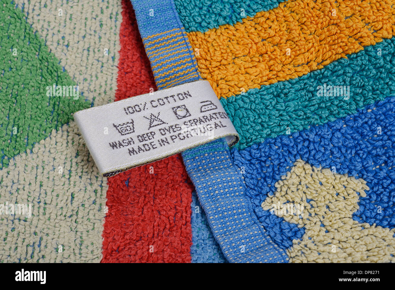 Etichetta di cura sull'orlo di un asciugamano colorato Foto Stock