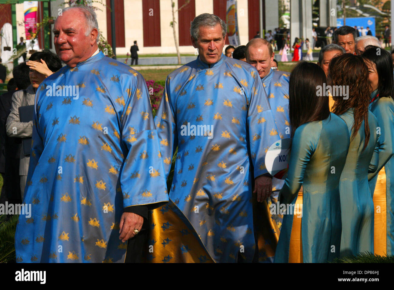 (L a R) Perù il primo Vice Presidente Luis Giampietri, U.S. Il Presidente Bush e il Presidente russo Vladimir Putin indossando il tradizionale abbigliamento vietnamiti conosciuta come 'ao dai', arrivano a una foto di famiglia della Cooperazione economica Asia-Pacifico (APEC ) vertice di Hanoi, domenica 19 novembre, 2006. (Credito Immagine: © PhotoXpress/ZUMA Premere) Restrizioni: America del Nord e del Sud Foto Stock