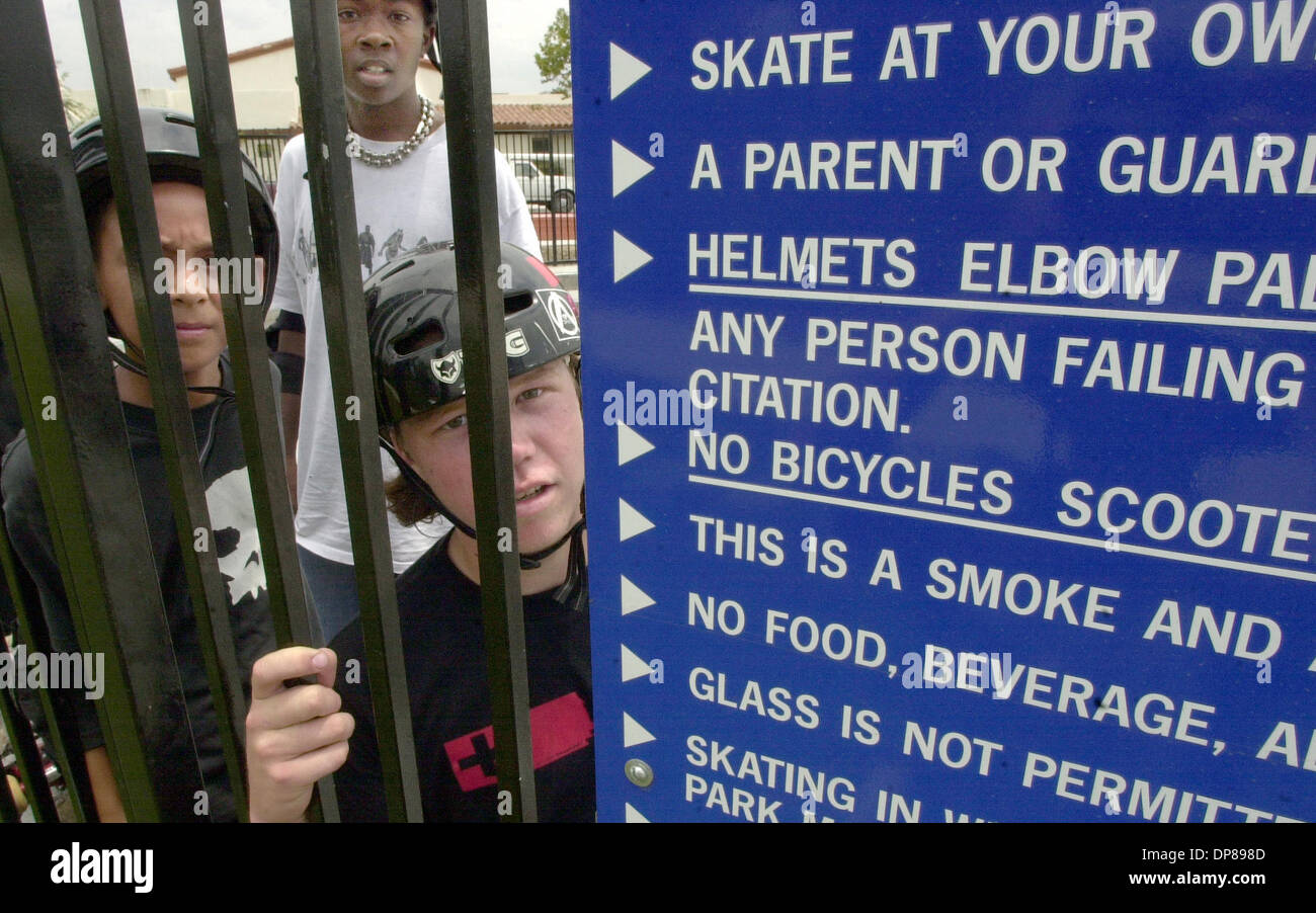 (Pubblicato il 18/07/2003, NI-1) a Portland's skate park skateboarders utilizzando caschi guardare attraverso la recinzione dove uno dei segni che mostra la struttura di regole è pubblicato (giunsero alla recinzione chiedete al fotografo di cosa stava fotografando). I.D., LtoR: Nolan vivace, 9, LAMONT ALEXANDER, 14 (sopra), e Kenny HUFFMAN, 16, estrema destra. U/T foto CHARLIE NEUMAN Foto Stock