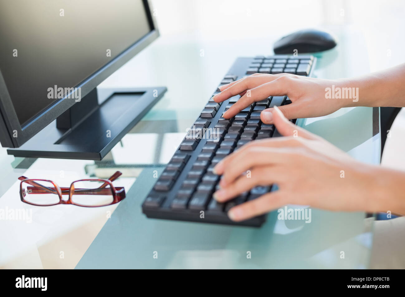 Close up di mani femminili digitando sulla tastiera a scrivania Foto Stock