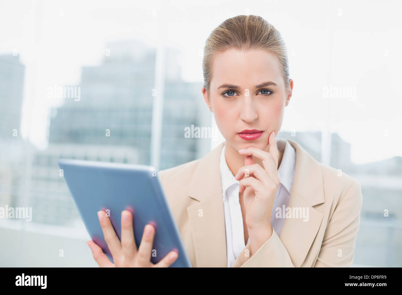 Grave attraente imprenditrice utilizzando il suo tablet Foto Stock