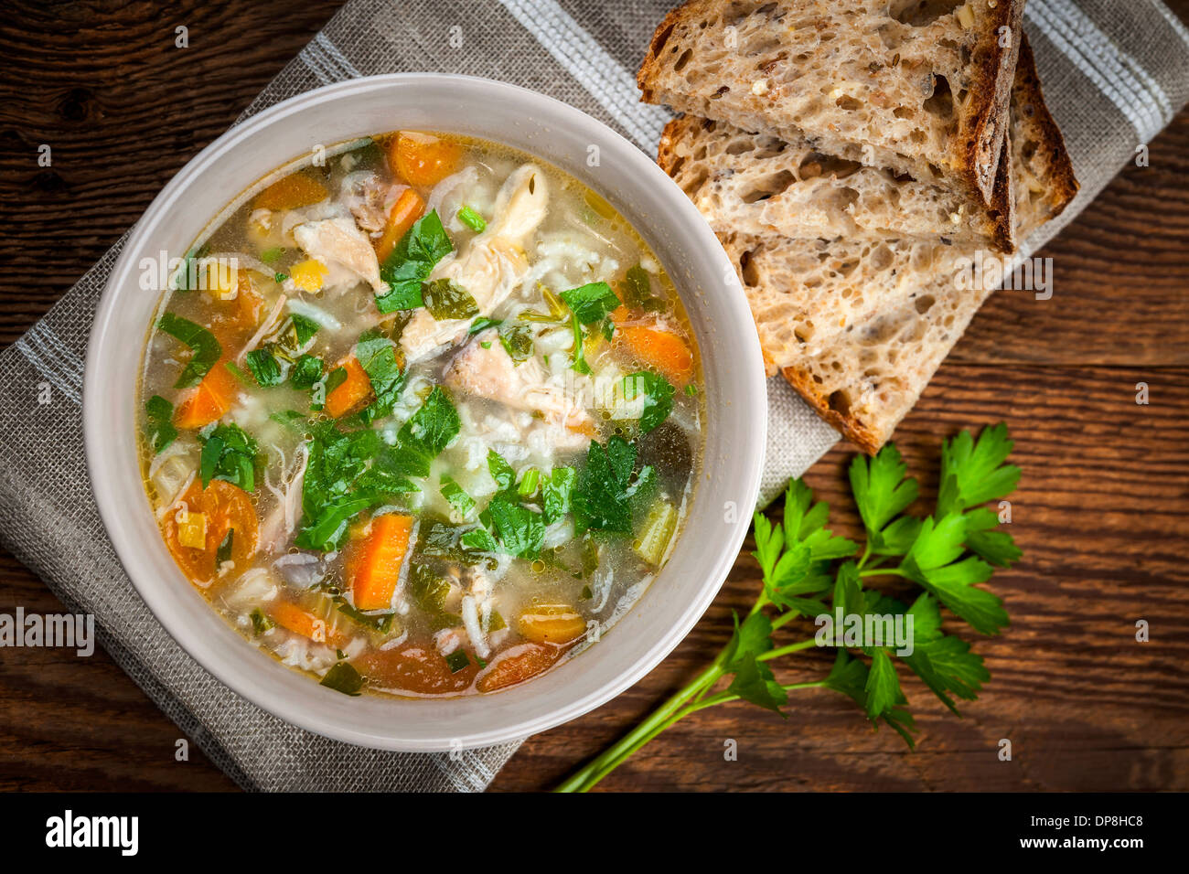 Pollo zuppa di riso con le verdure in una terrina e pane da sopra Foto Stock