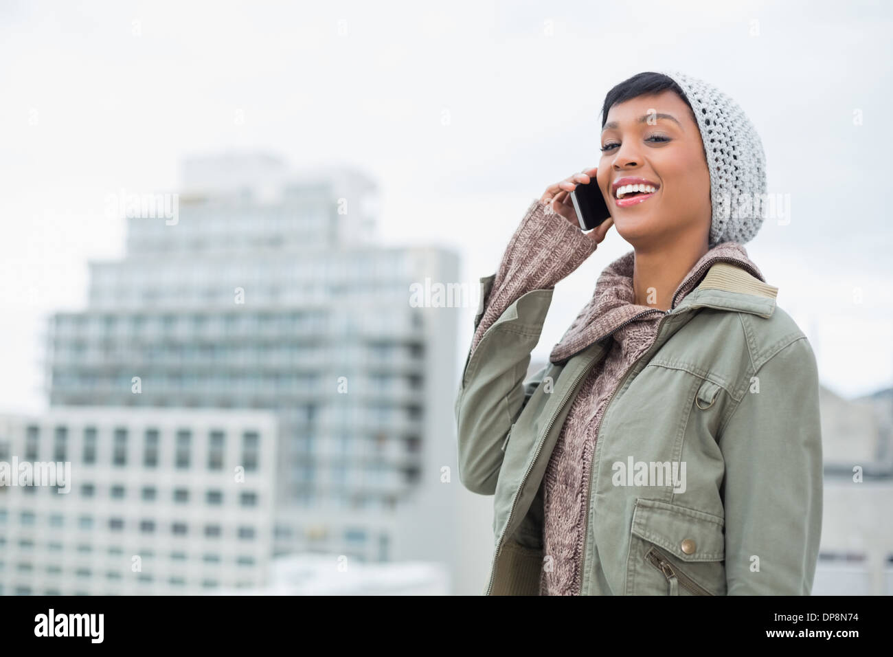 Ridendo giovani modello in abbigliamento invernale rispondere il suo telefono Foto Stock
