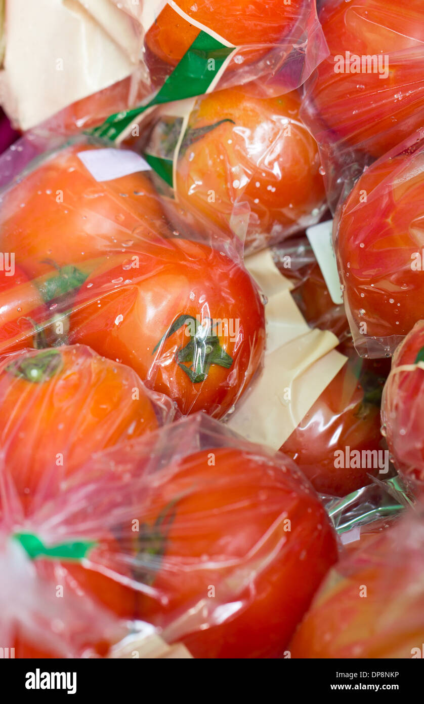 Close up di pomodori freschi confezionati in buste di plastica nel mercato. Foto Stock