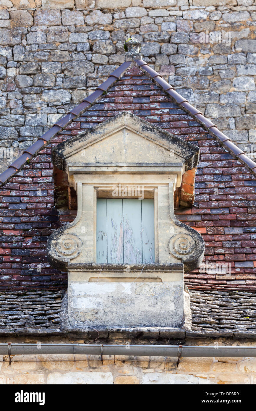 Domme, Dordogne, la Francia, l'Europa. Inusuale finestra sul tetto di un vecchio edificio tradizionale. Foto Stock