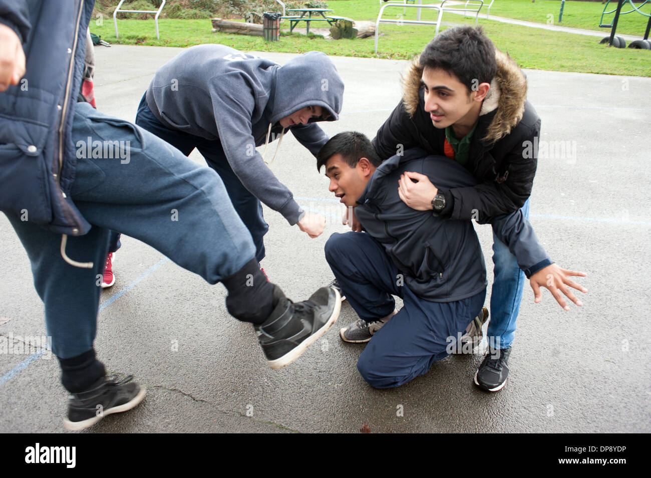 Un ragazzo adolescente di essere aggredito da un gruppo di ragazzi. Foto Stock