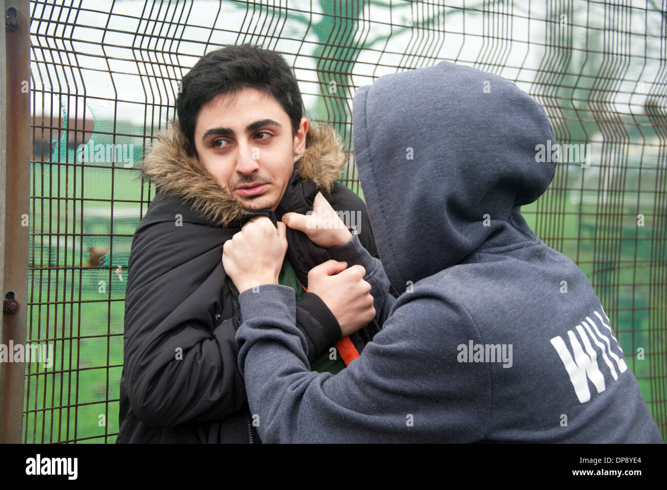 Un giovane uomo di essere vittima di bullismo da parte di un altro ragazzo adolescente. Foto Stock