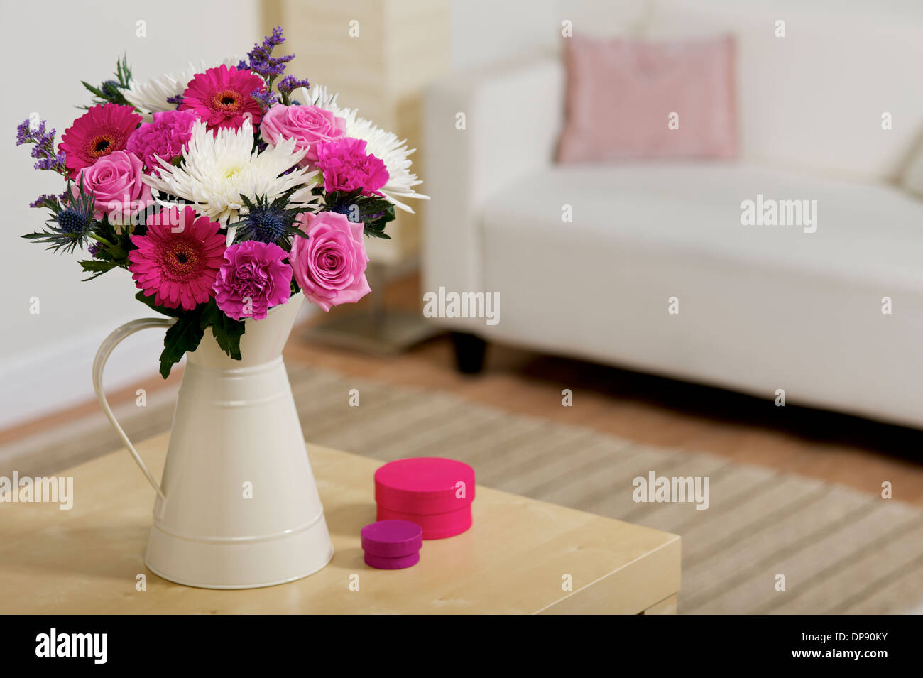 Bouquet di fiori rosa e bianchi in una crema vaso o brocca in una camera settings Foto Stock