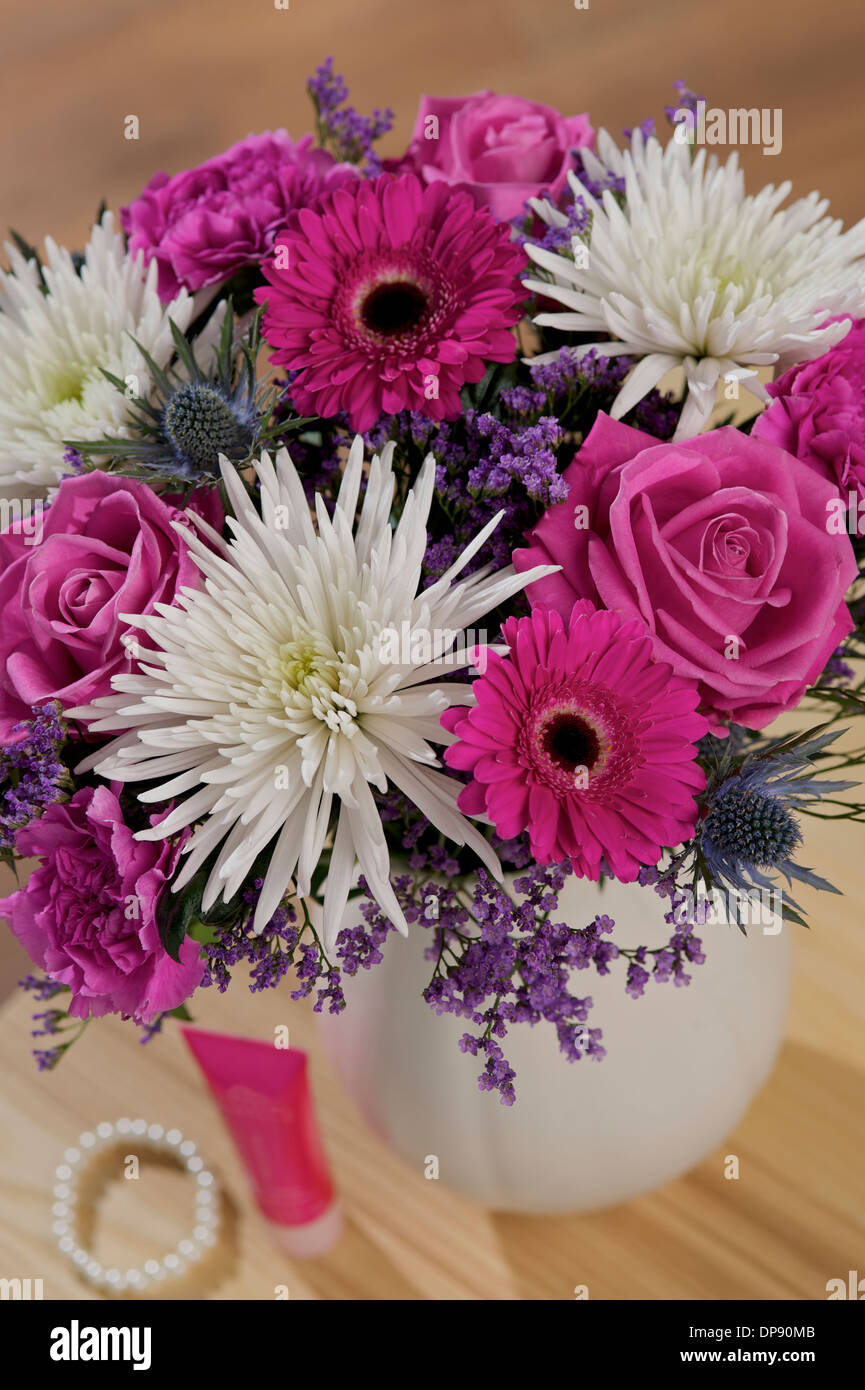 Thistle Sea Holly Eryngium Bourgatii, cerise Gemini, rosa Aqua Roses, limonio viola, garofani rosa e Anastasia bianca in un vaso in un ambiente domestico Foto Stock