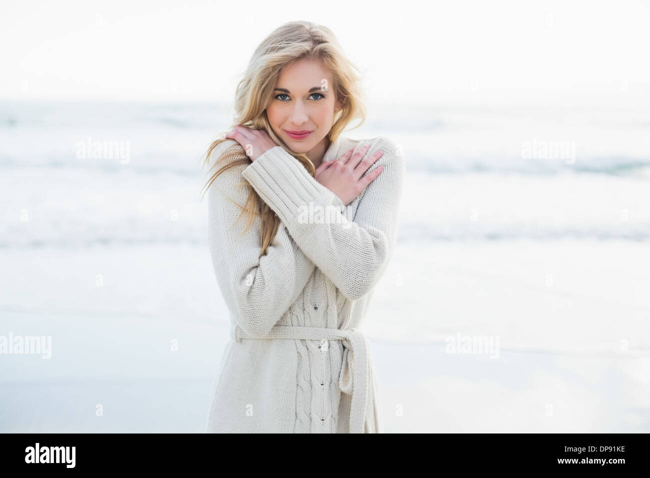 Carino donna bionda in lana cardigan in fase di riscaldamento Foto Stock