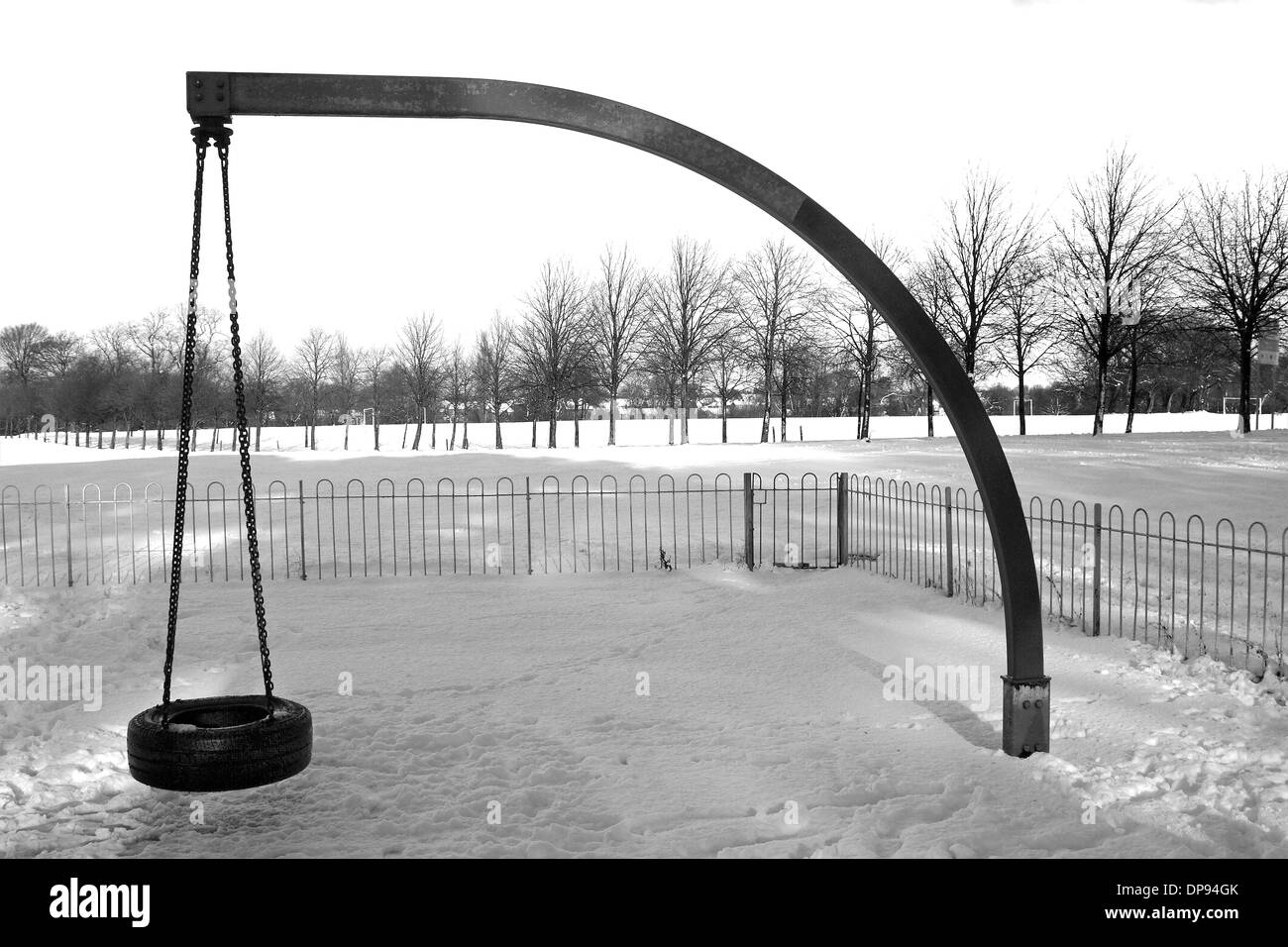 Immagine in bianco e nero di swing in una coperta di neve area gioco per bambini, Moor Park, Preston, Lancashire Foto Stock