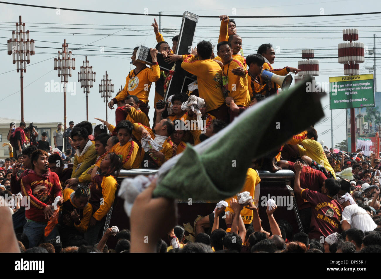 Manila, Filippine. Il 9 gennaio, 2014. MANILA, Filippine - un devoto onde il suo asciugamano mentre la folla grida "Viva!" come cattolici filippini devoti di prendere parte all'annuale ''Traslacion'', termine spagnolo per il movimento o passaggio, durante la festa del Nazareno nero a Manila . Il Nazareno nero è un vecchio di secoli l immagine di Gesù Cristo che porta la croce e che è ampiamente creduto di compiere miracoli. ws Credito: ZUMA Press, Inc./Alamy Live News Foto Stock