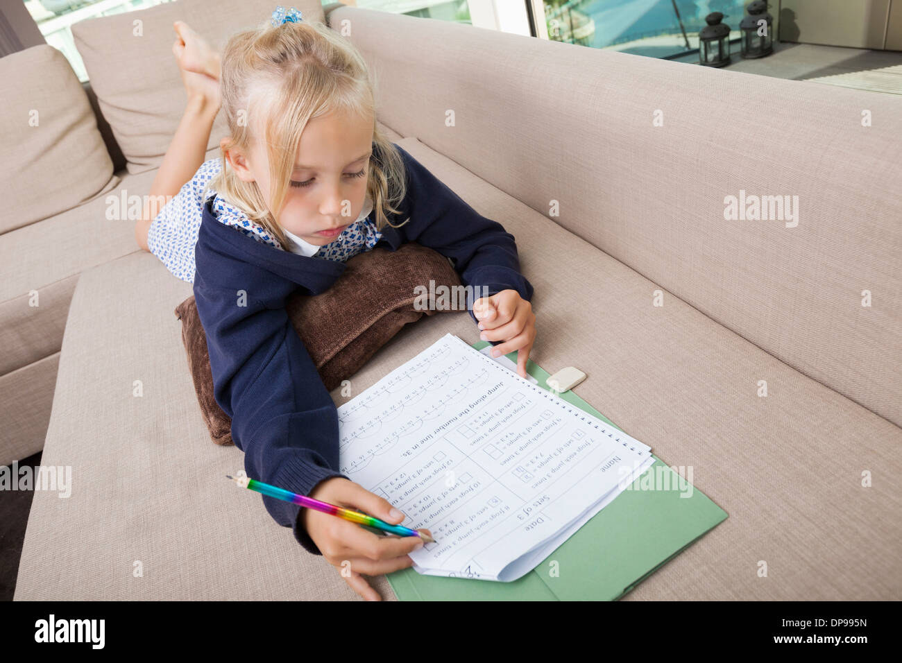 Bambina risolvere matematica somme sul divano Foto Stock