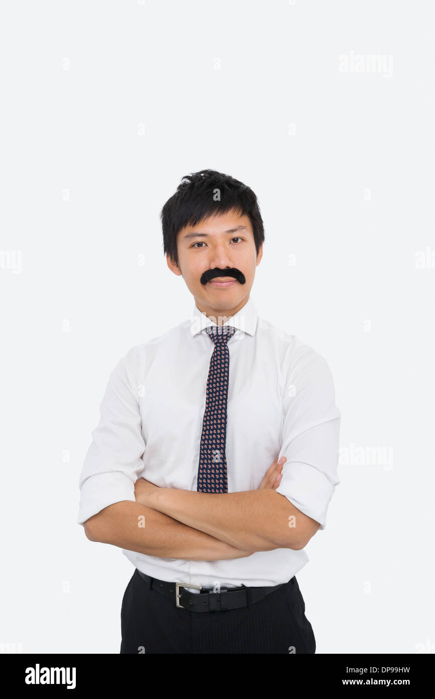 Ritratto di fiducioso imprenditore con baffi finti su sfondo bianco Foto Stock