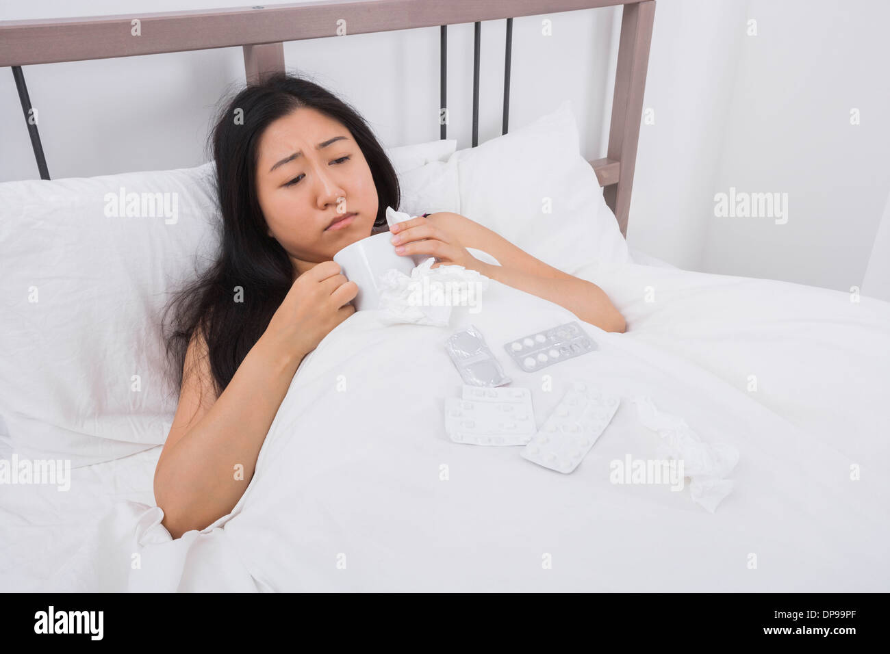 La donna che soffre di freddo che il caffè a letto Foto Stock