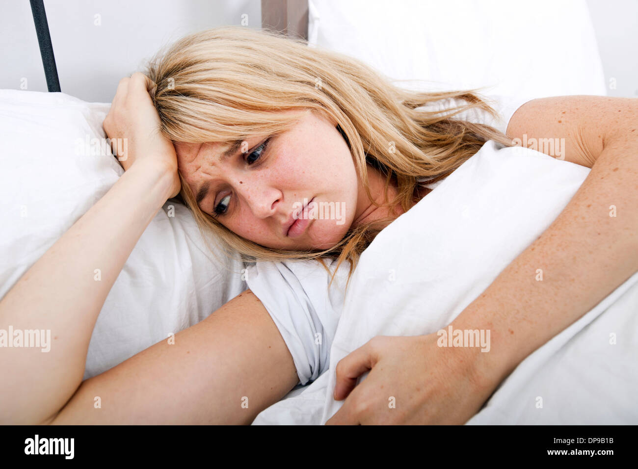 Giovane donna che soffre di mal di testa nel letto Foto Stock