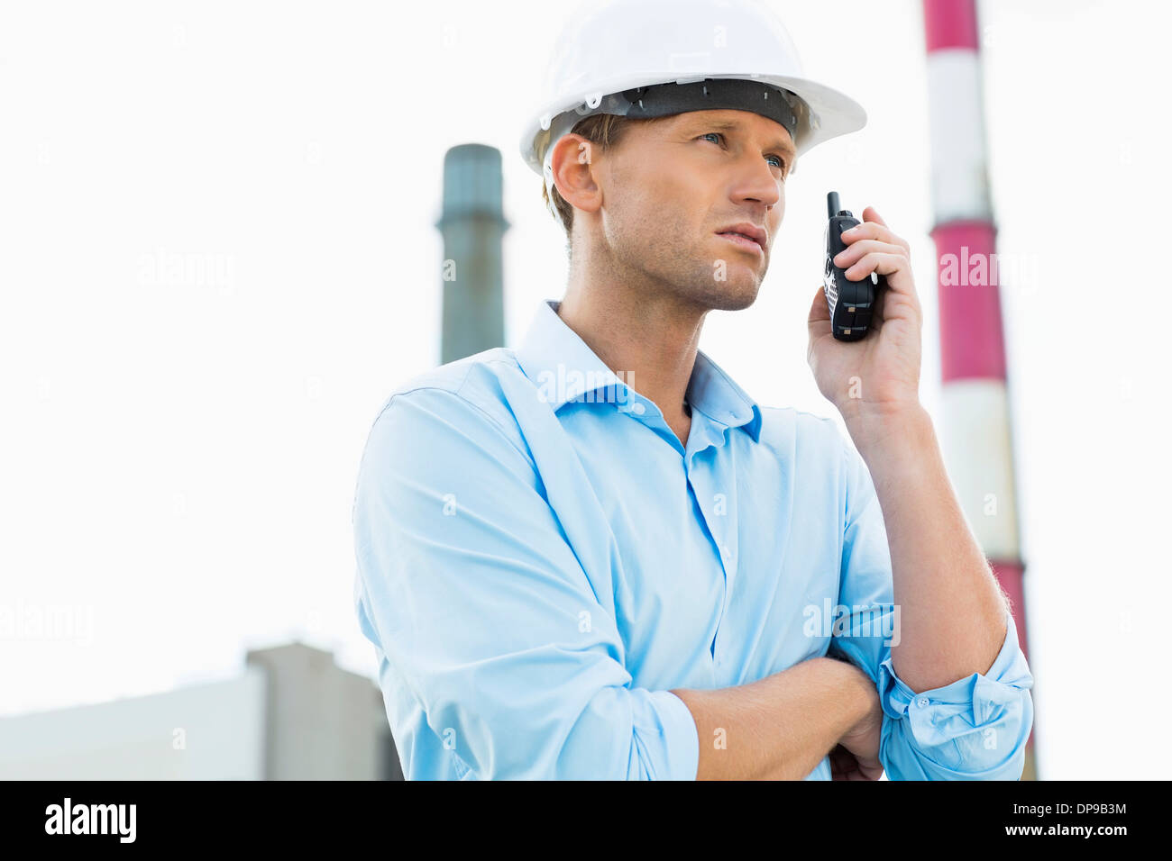 Architetto maschio comunicando su un walkie-talkie presso il sito Foto Stock