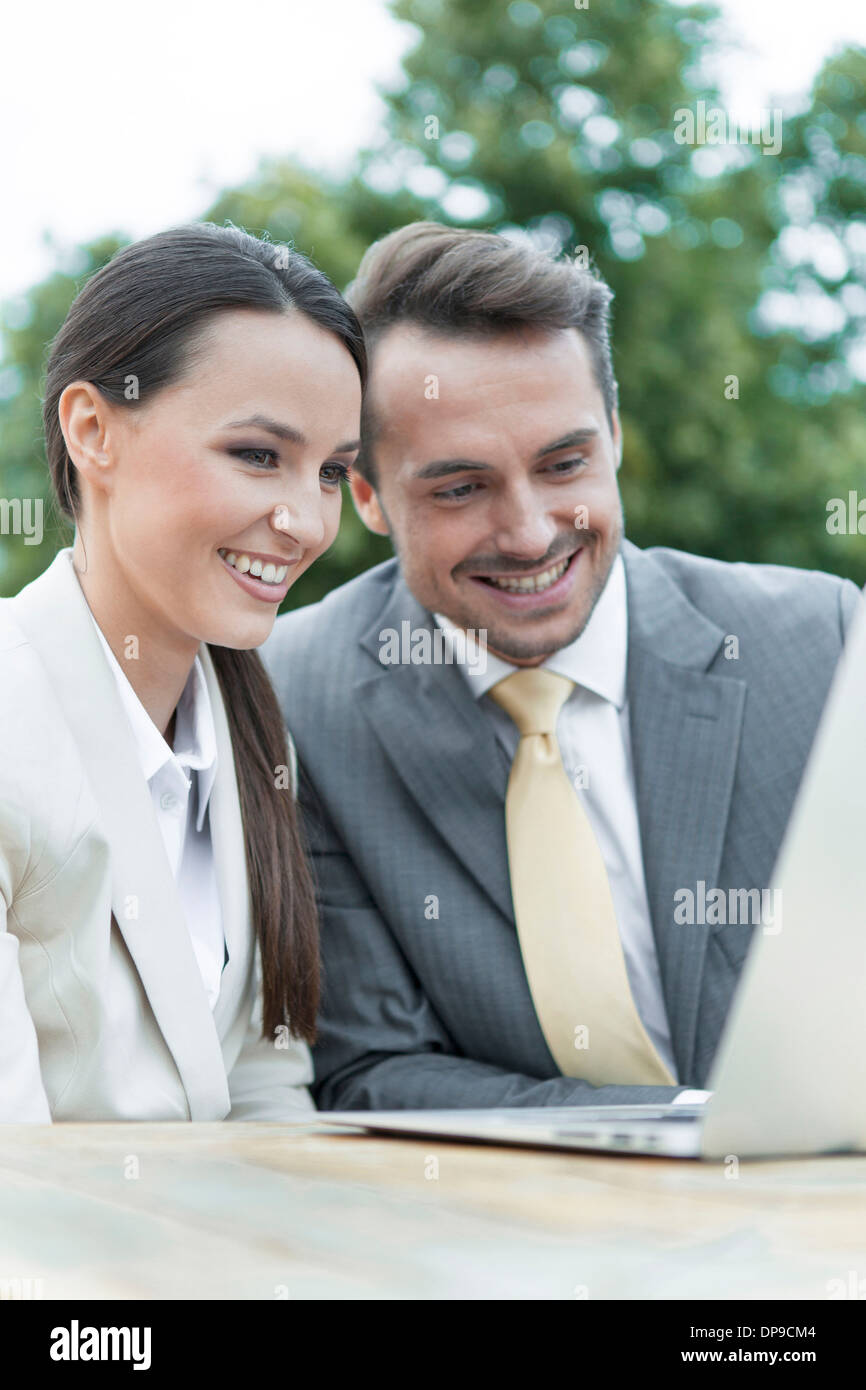 Happy businessman utilizzando laptop all'aperto Foto Stock