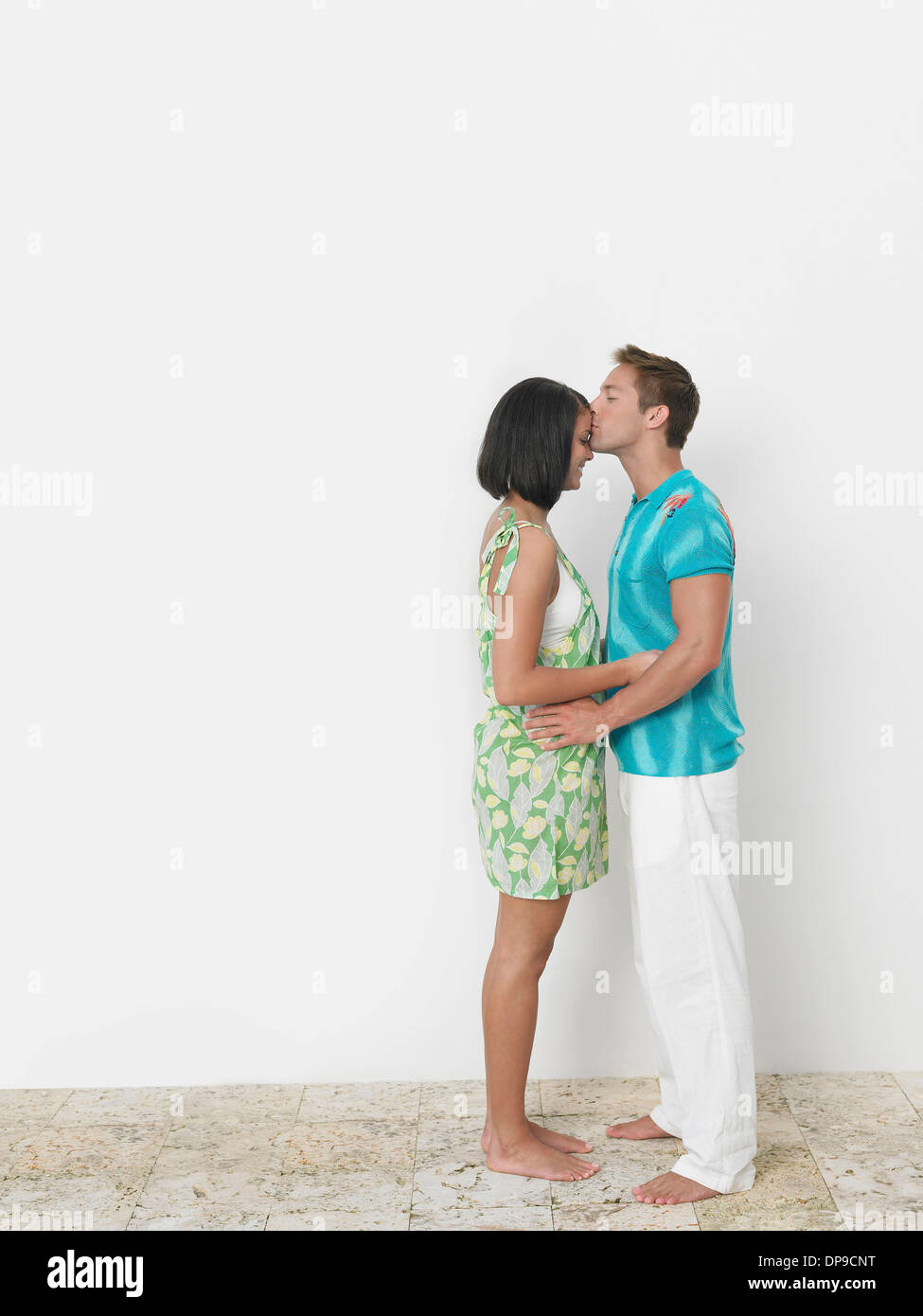 Amare giovane kissing donna di fronte contro la parete Foto Stock