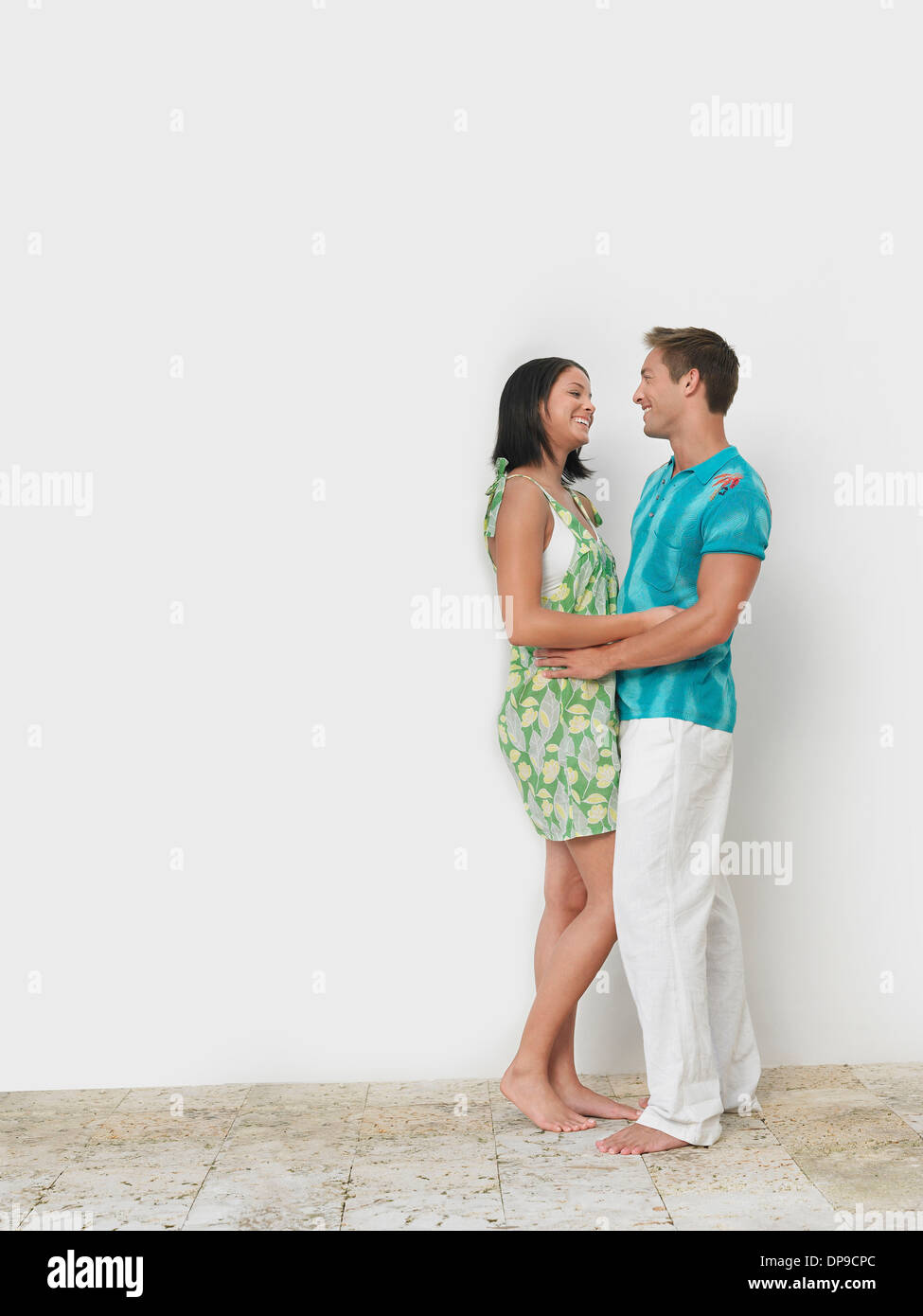 Amorevole coppia giovane in piedi contro la parete Foto Stock