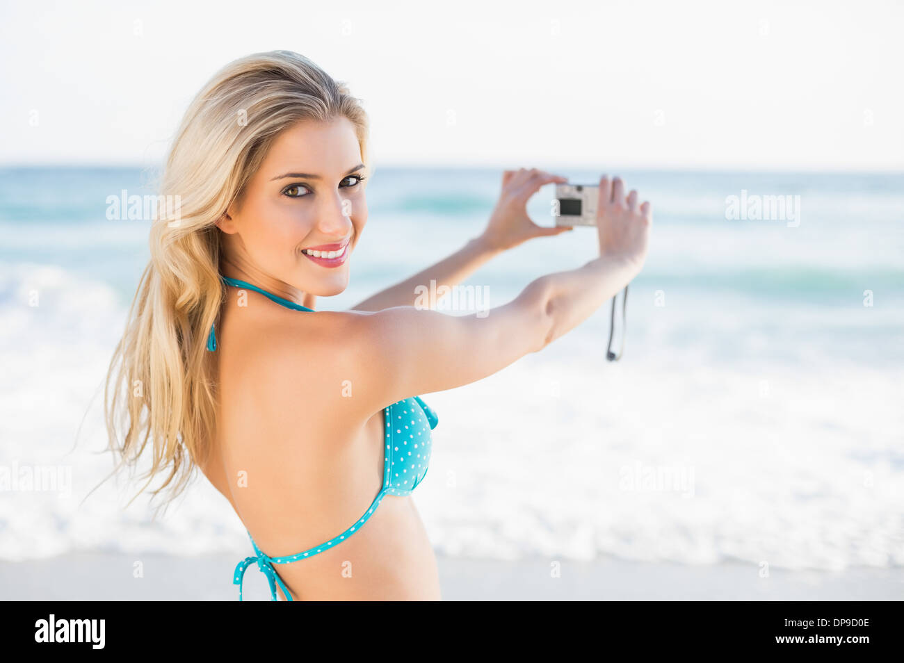 Attraente bionda in bikini prendendo un auto picture guardando la fotocamera Foto Stock