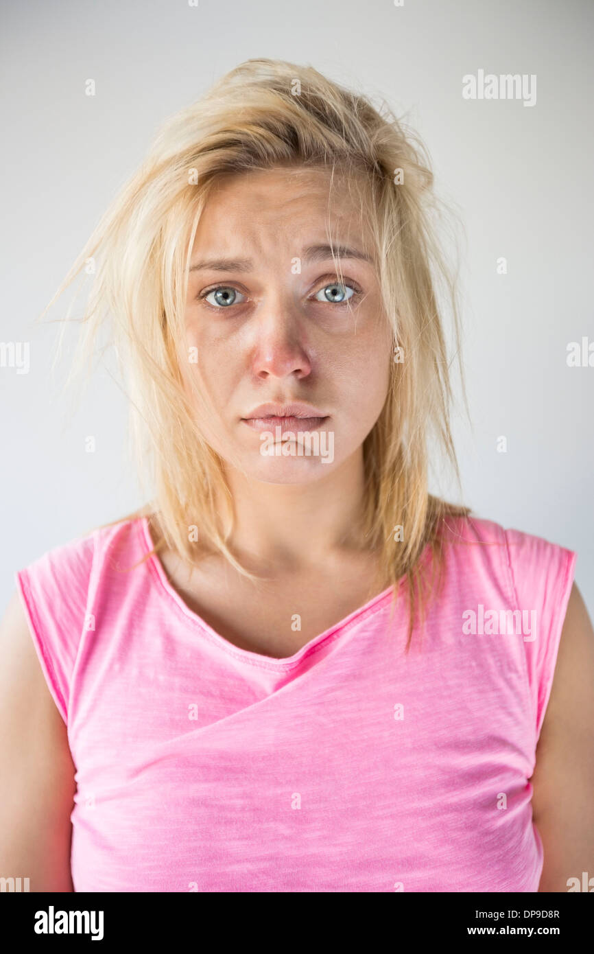 Ritratto di donna triste soffrono di freddo contro uno sfondo grigio Foto Stock