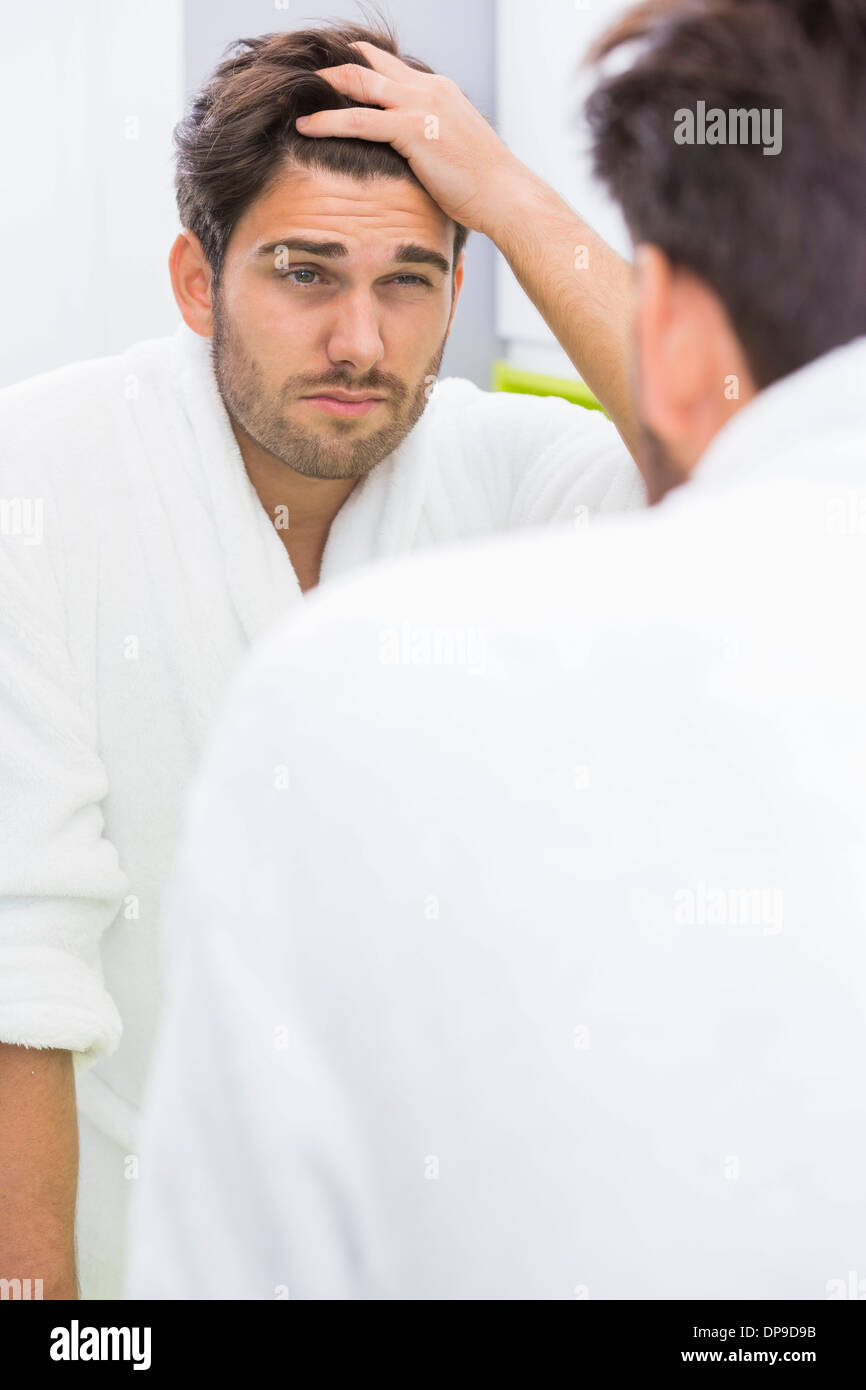 La riflessione di uomo che soffre di mal di testa in specchio Foto Stock