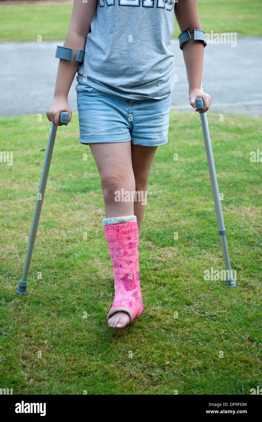 Ragazza adolescente su stampelle Gamba rotta intonaco rosa modello  completamente rilasciato Foto stock - Alamy