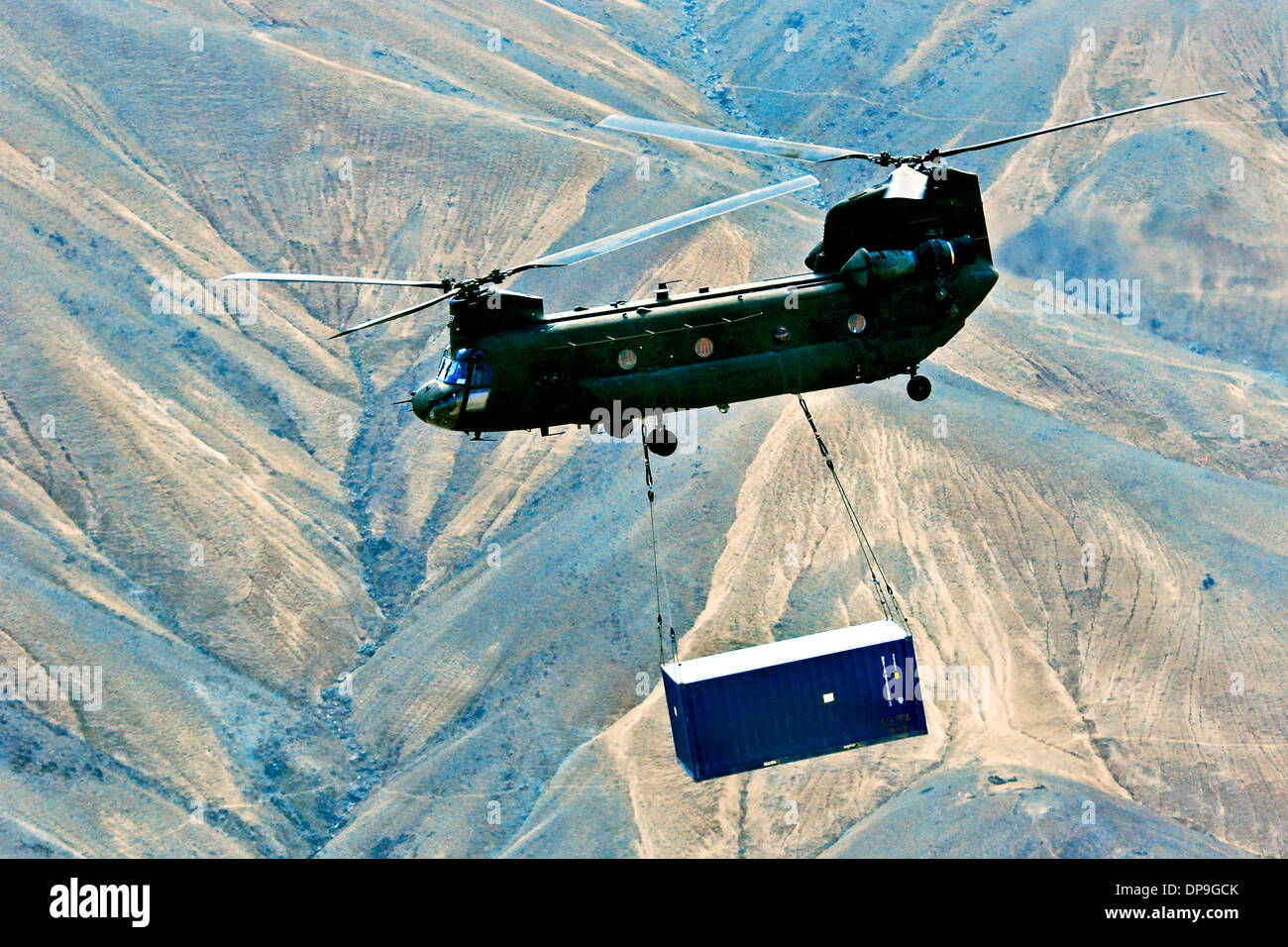 Stati Uniti Esercito CH-47 elicottero Chinook porta una fionda caricata a contenitore di spedizione in Afghanistan Foto Stock