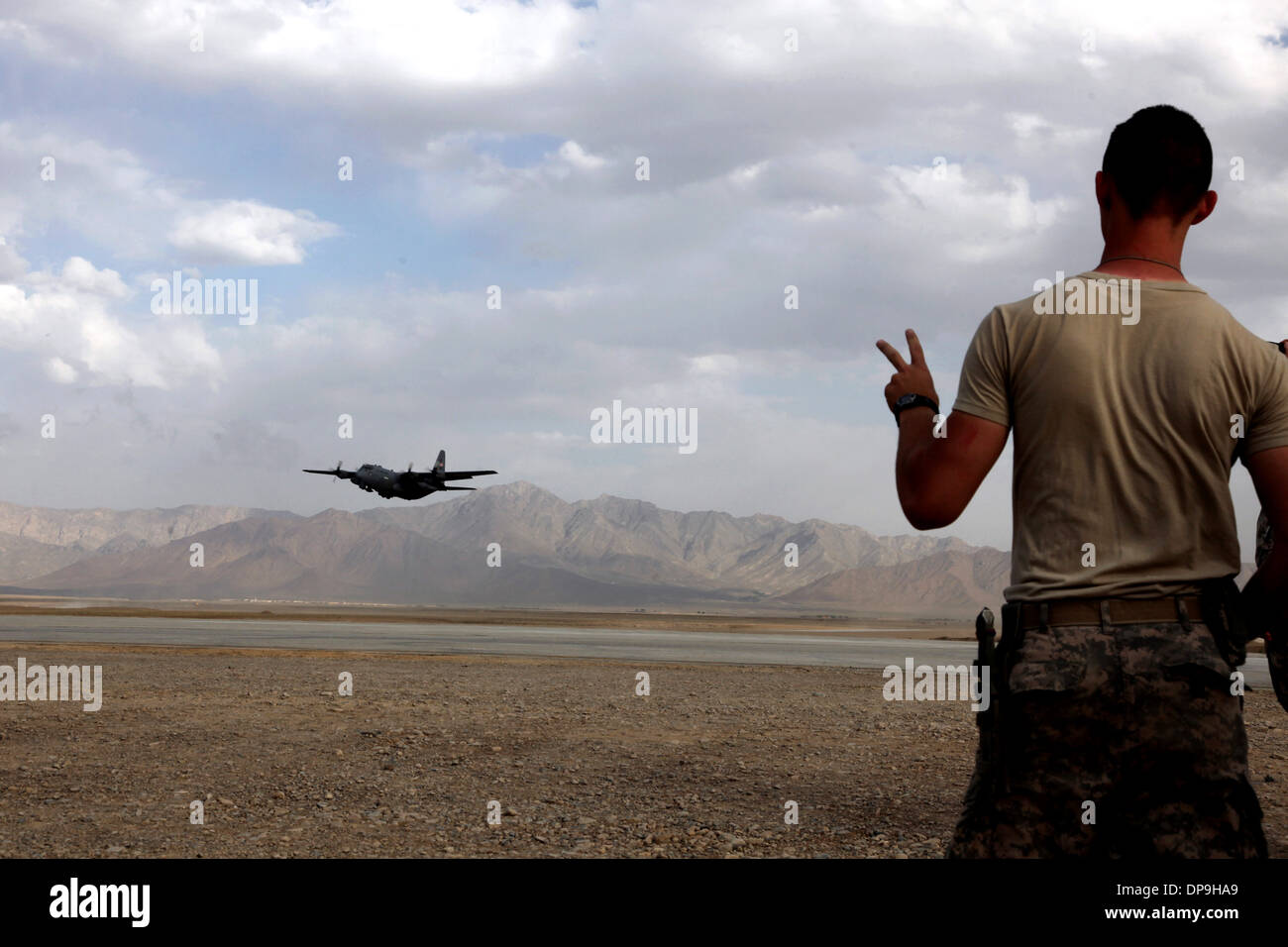 Soldato nordamericano onde da un C-130 Hercules aeromobili cargo uscire avanti Base Operativa gambo, provincia di Logar, Afghanistan Foto Stock