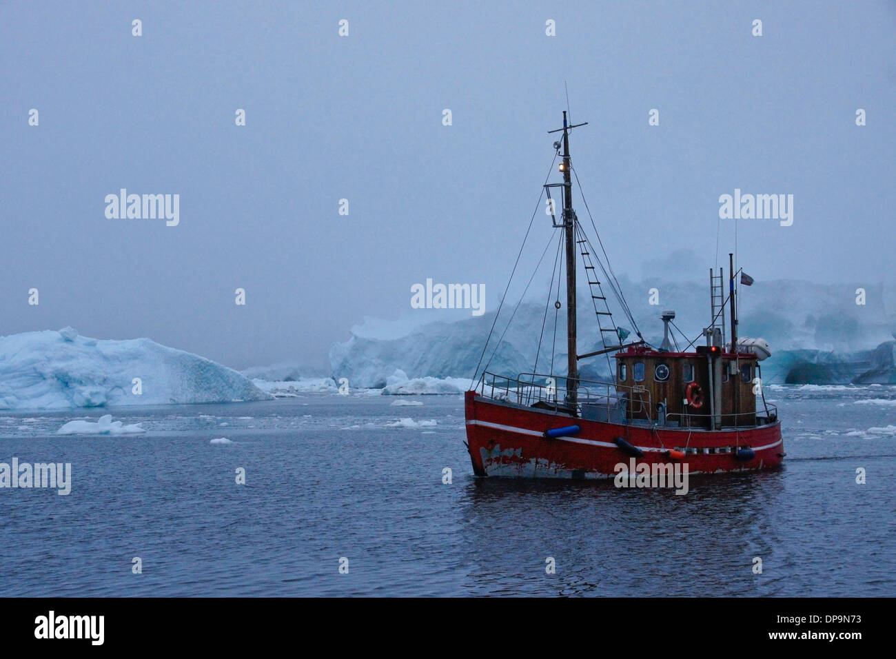 Barca da pesca e iceberg nella nebbia, Disko Bay, Ilulissat, Groenlandia occidentale Foto Stock