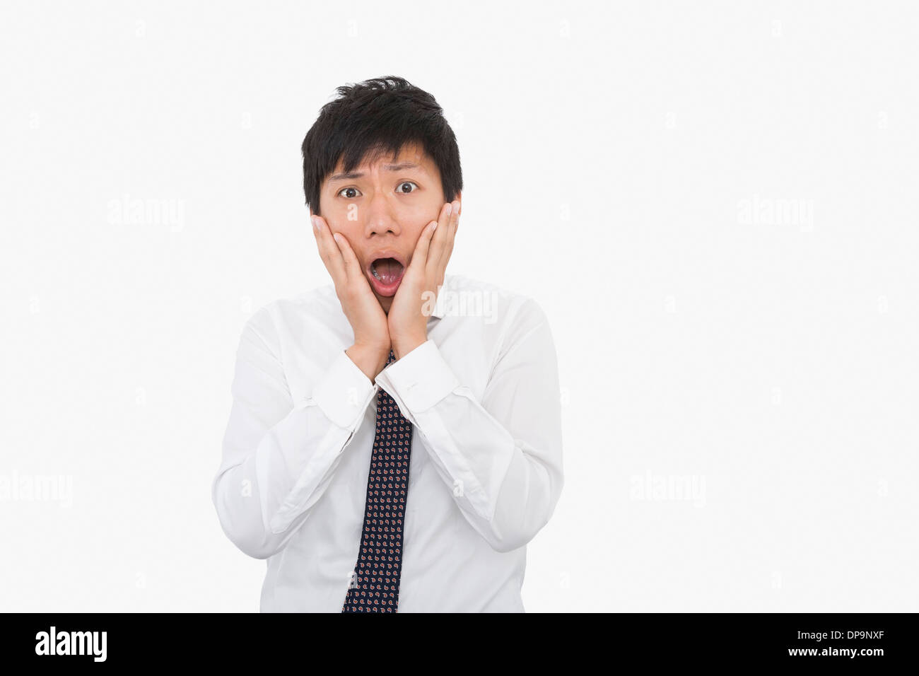 Scioccato adulto medio imprenditore con le mani sulla faccia su sfondo bianco Foto Stock