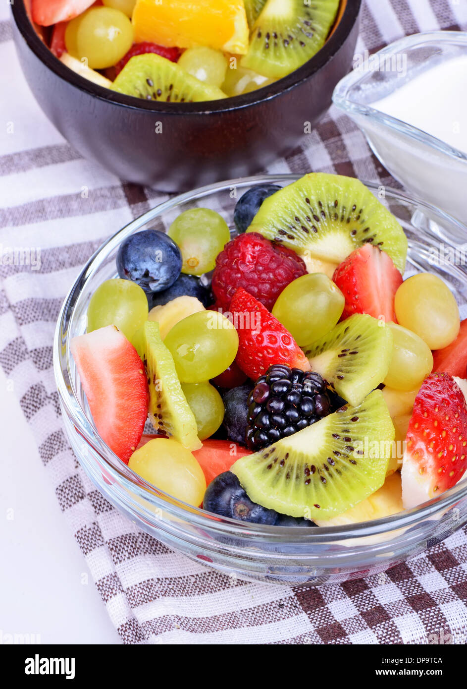 Macedonia di frutta con fragole, arance, kiwi e mirtilli isolati su sfondo bianco Foto Stock