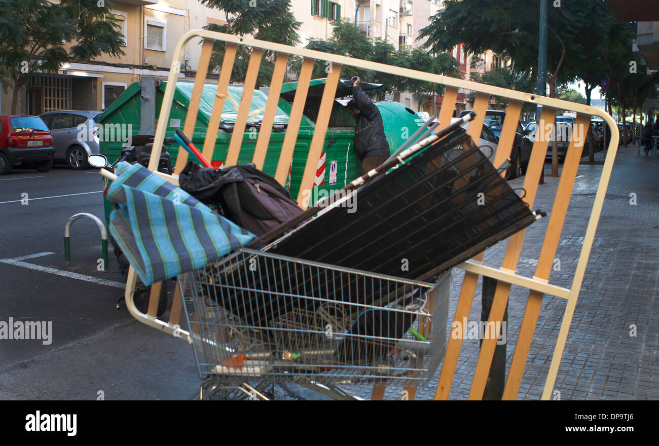 Un junkman spinge il suo carrello dove egli sceglie tra la posta indesiderata in rame, ferro e acciaio per seel su local junkyards, Mallorca, Spagna Foto Stock
