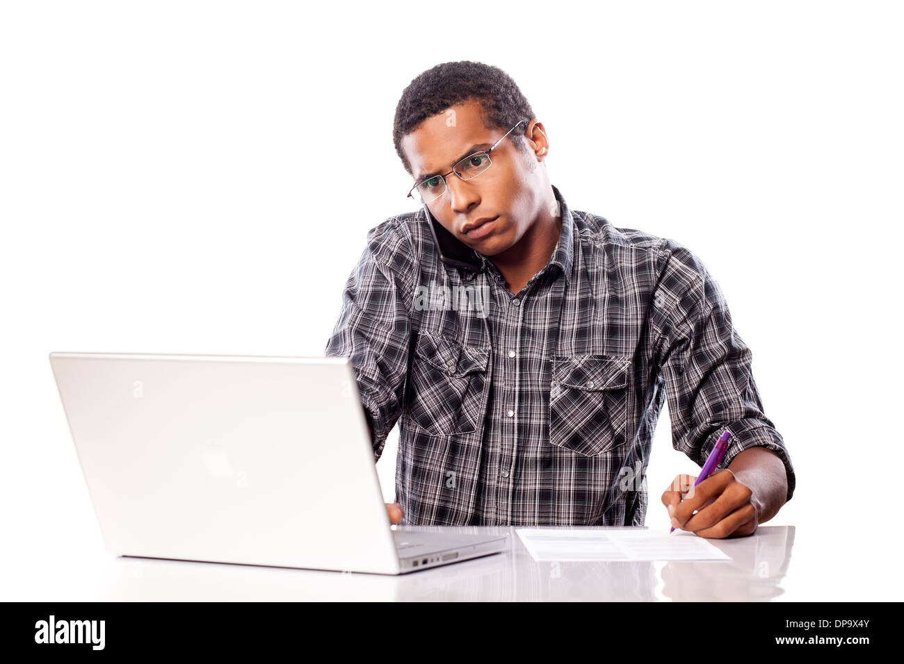 Grave giovane uomo nero scrive i dati dal suo computer portatile Foto Stock