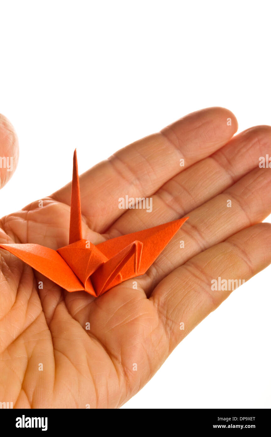 Mano che tiene un uccello origami Foto Stock