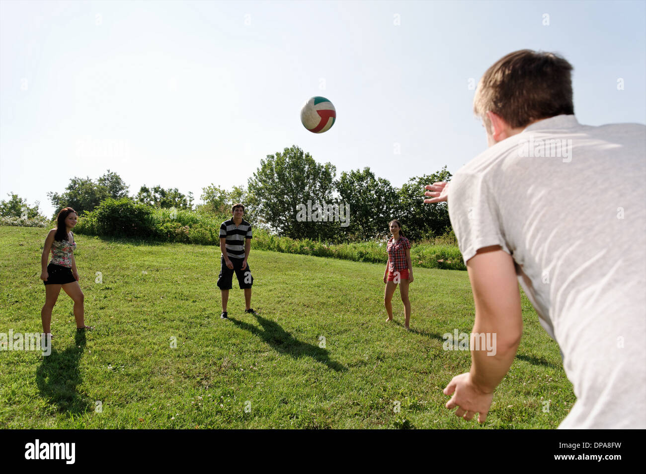 Un gruppo di giovani adulti a giocare il gioco del calcio Foto Stock