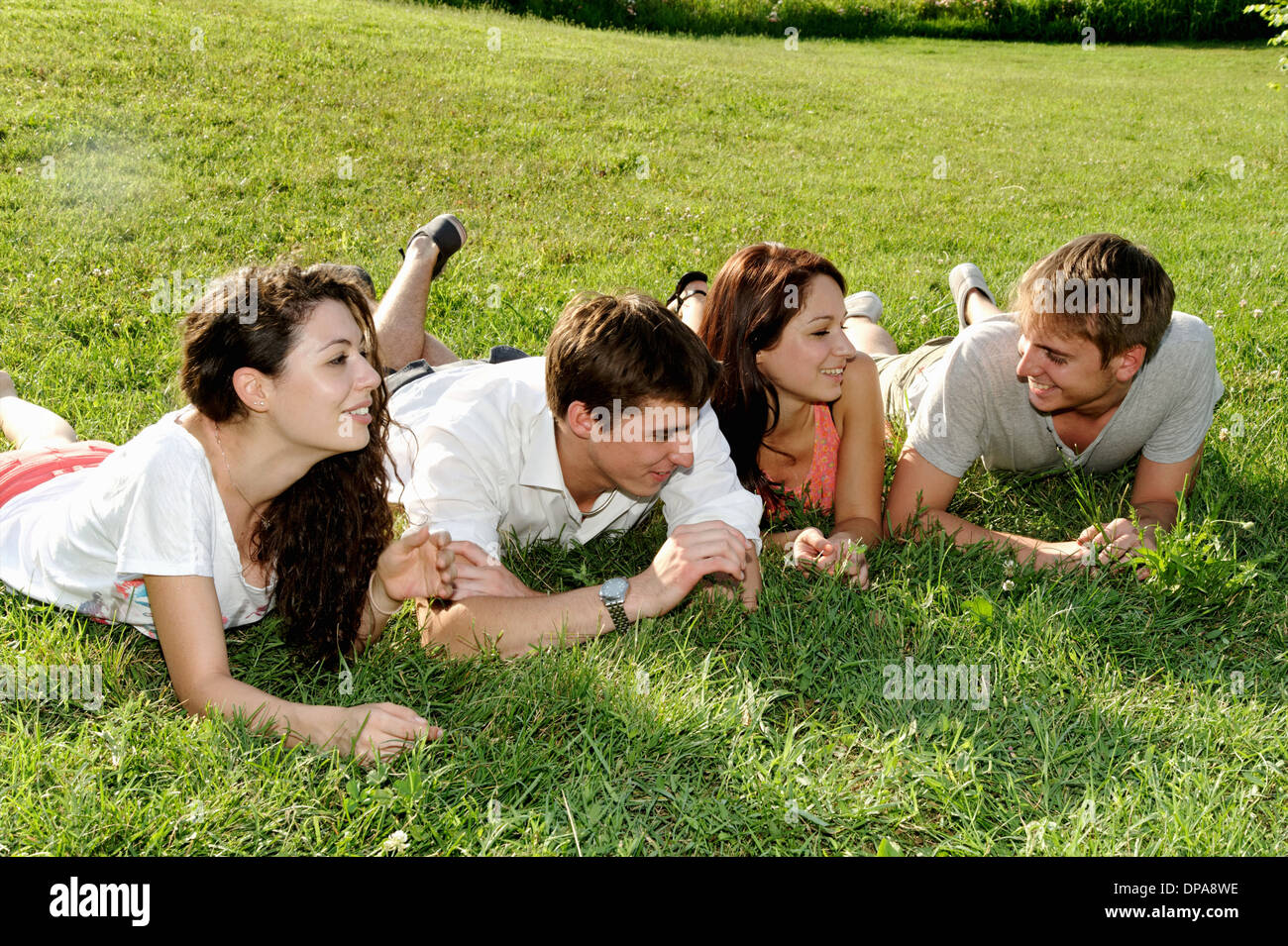 Un gruppo di giovani adulti sdraiati sull'erba Foto Stock