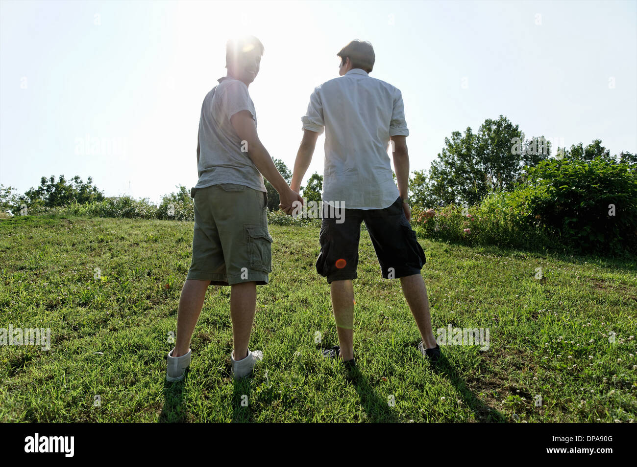 Due giovani uomini a piedi e tenendo le mani Foto Stock