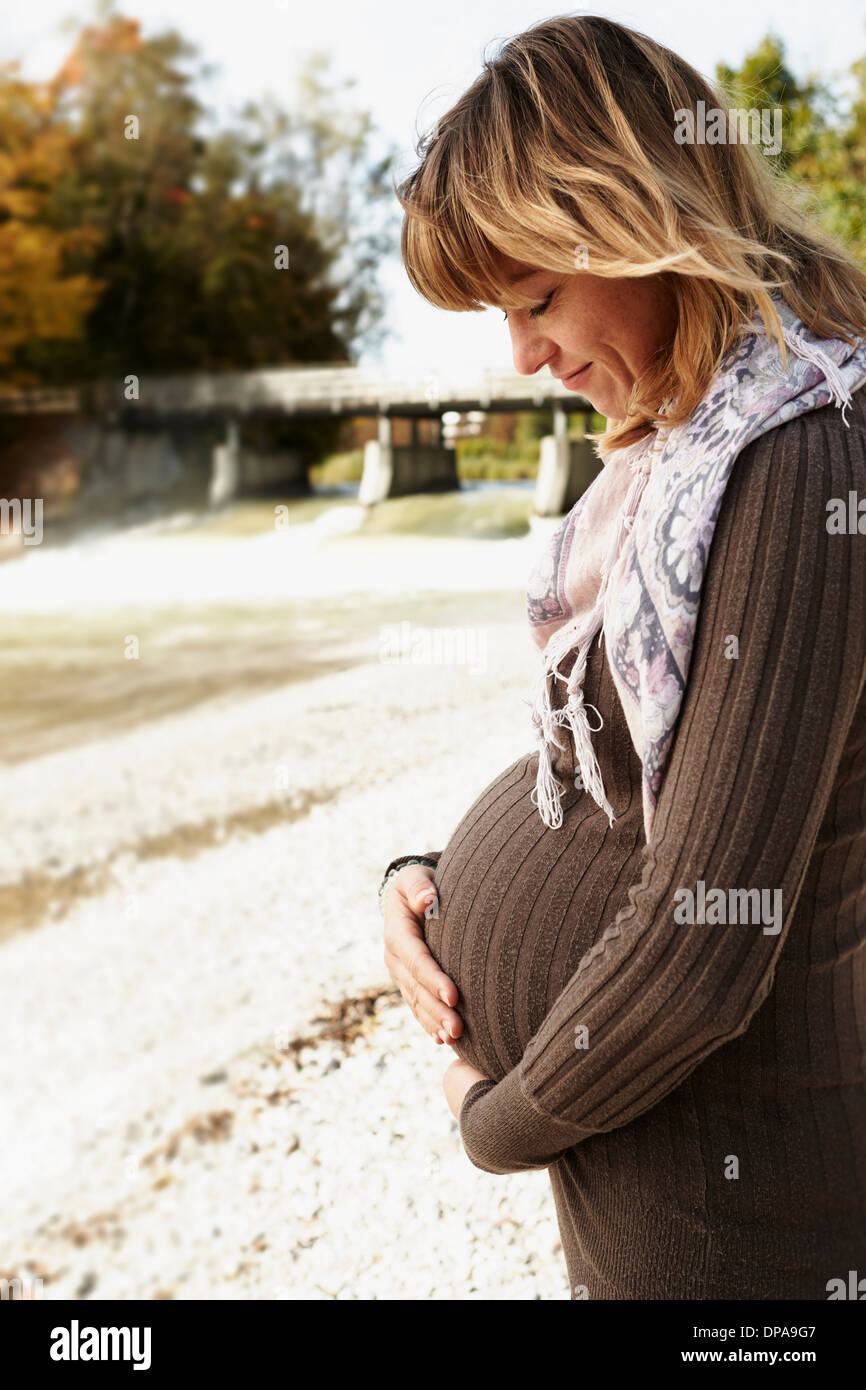 Ritratto di donna incinta guardando verso il basso Foto Stock