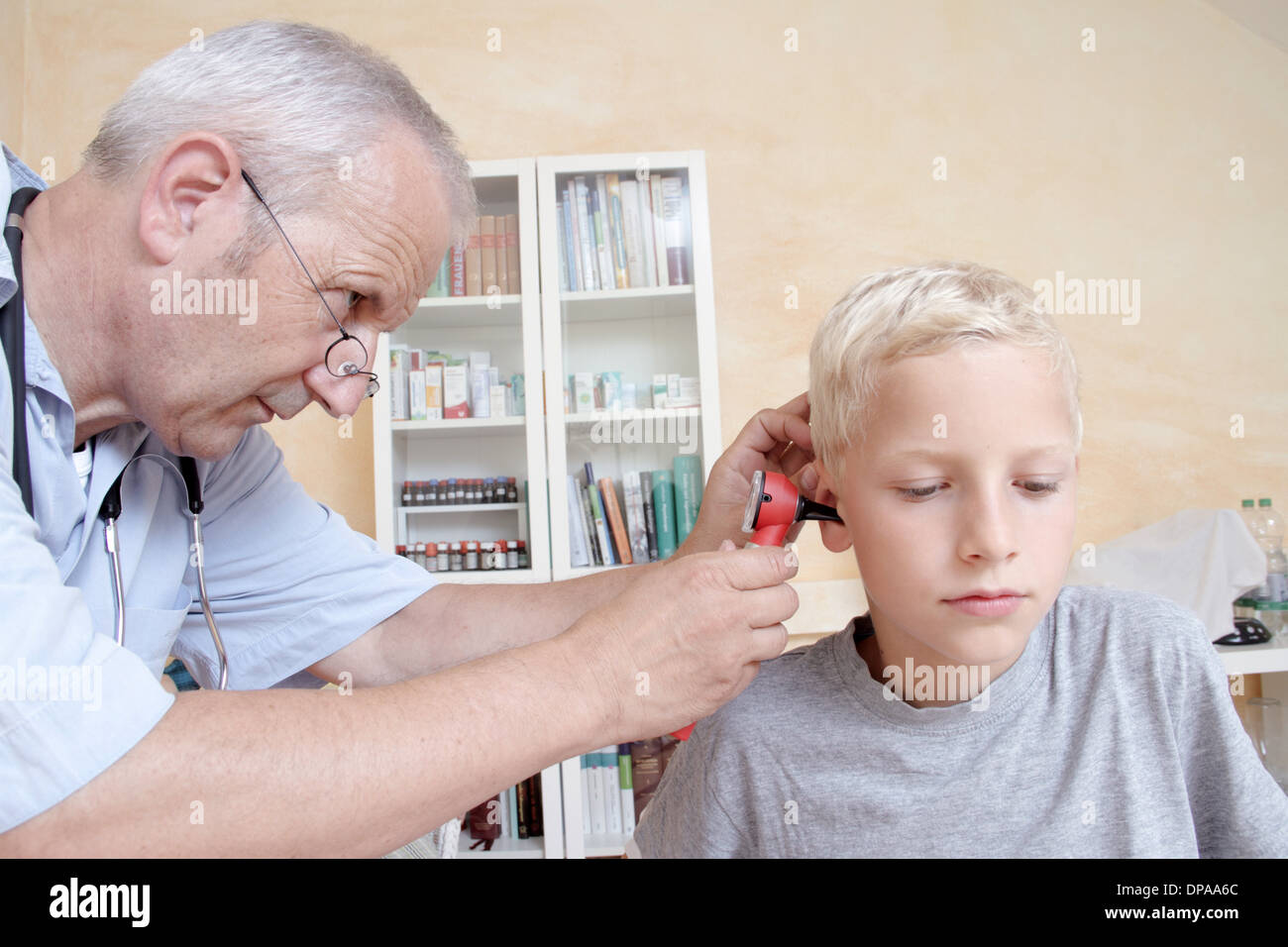 Medico esaminando boy l orecchio Foto Stock
