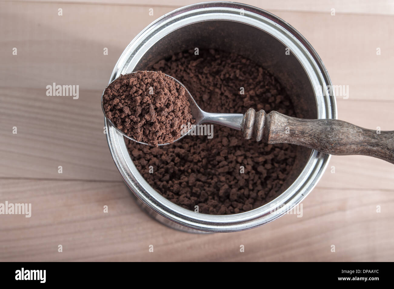 Aprire la confezione di caffè istantaneo e il cucchiaio sullo sfondo di legno Foto Stock