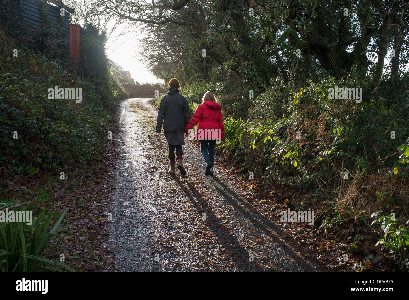 Una madre e figlia a piedi lungo una corsia in Cornwall, Regno Unito Foto Stock