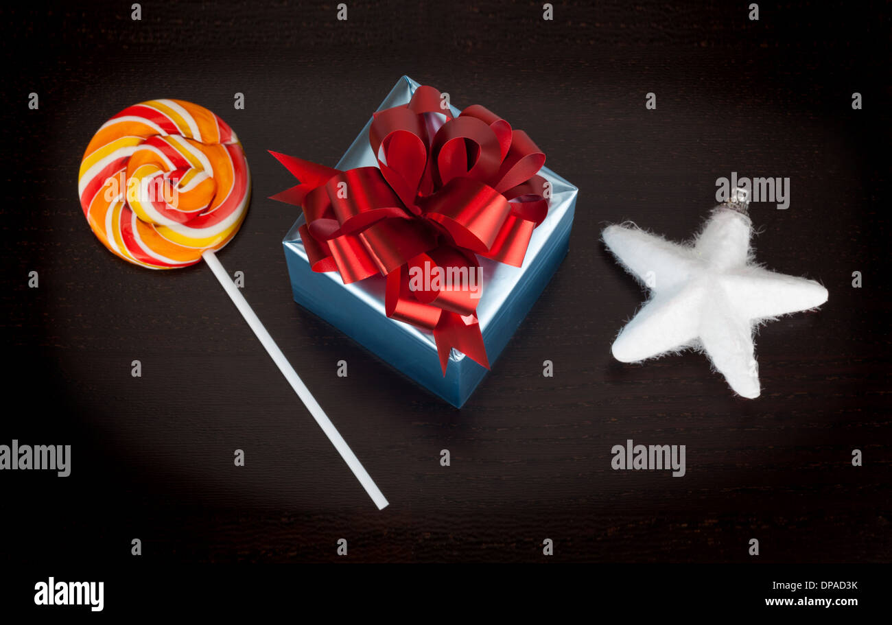 Blue box regalo, candycane e white christmas star nero su sfondo di legno Foto Stock