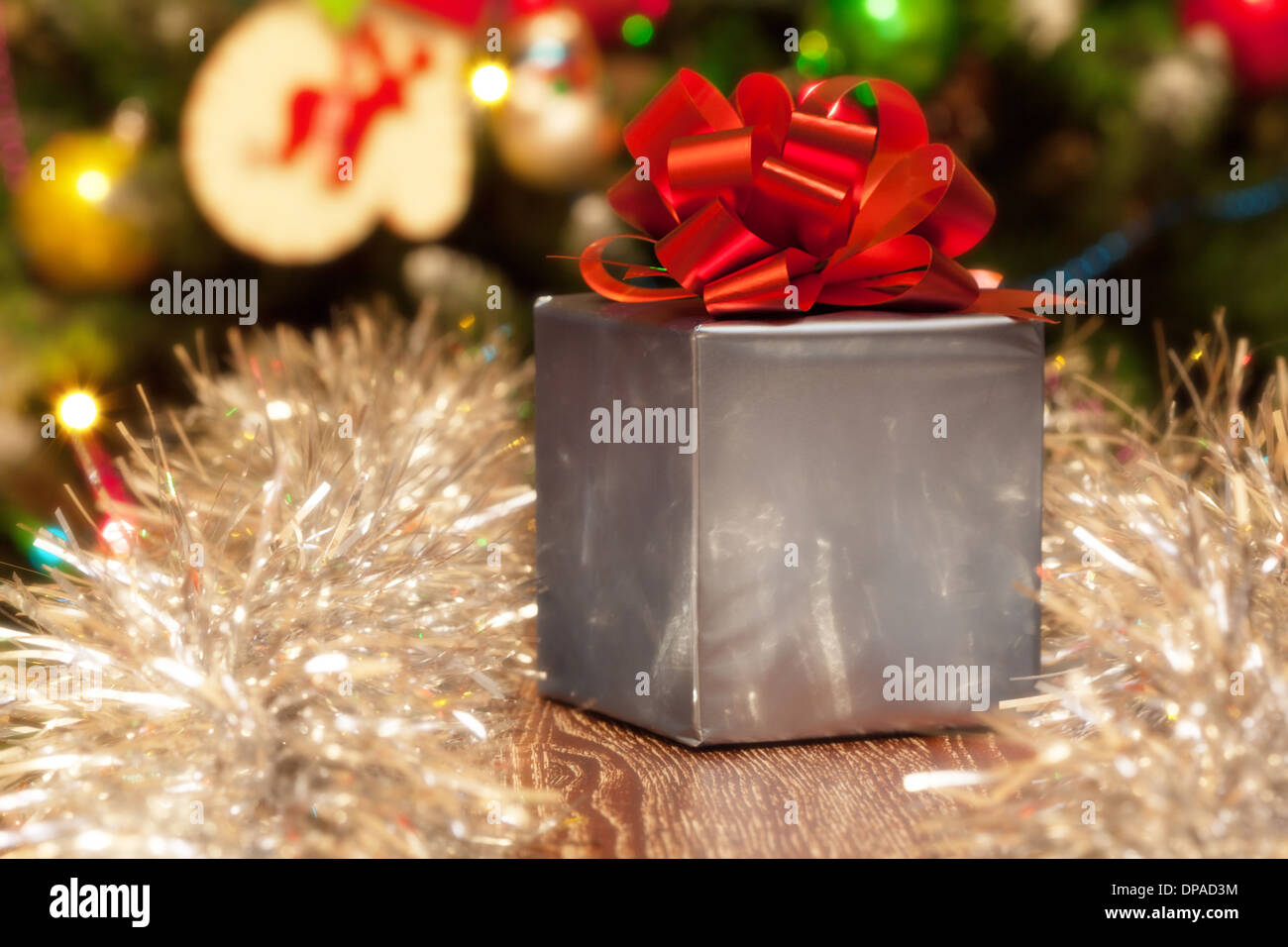 Argento Confezione regalo con nastro rosso sul Natale sfondo festivo Foto Stock