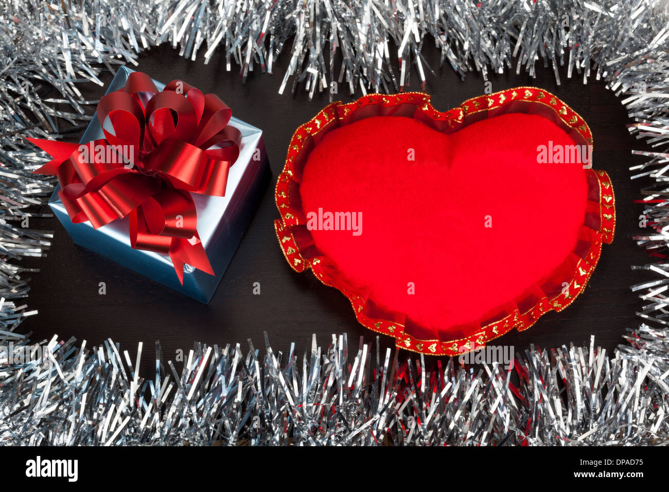 Regalo di san valentino scatola con forma di cuore giocattolo sul sottofondo in legno con glitter di festa Foto Stock